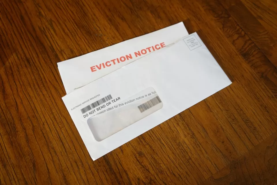 Eviction notice and envelope on wood floor.